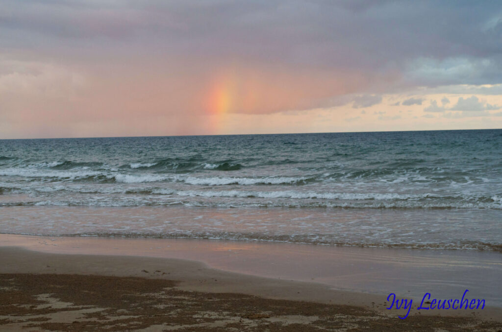 Rainbow in clouds over ocean