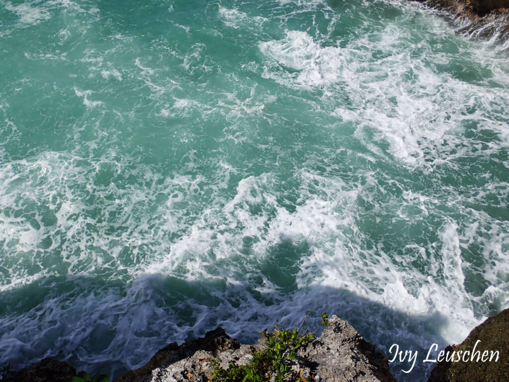 Turquoise water splashing against rocks