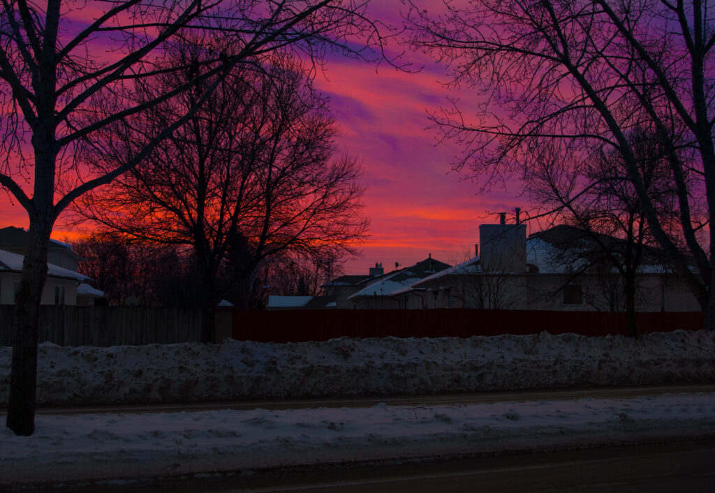 Purple and orange sunrise over houses